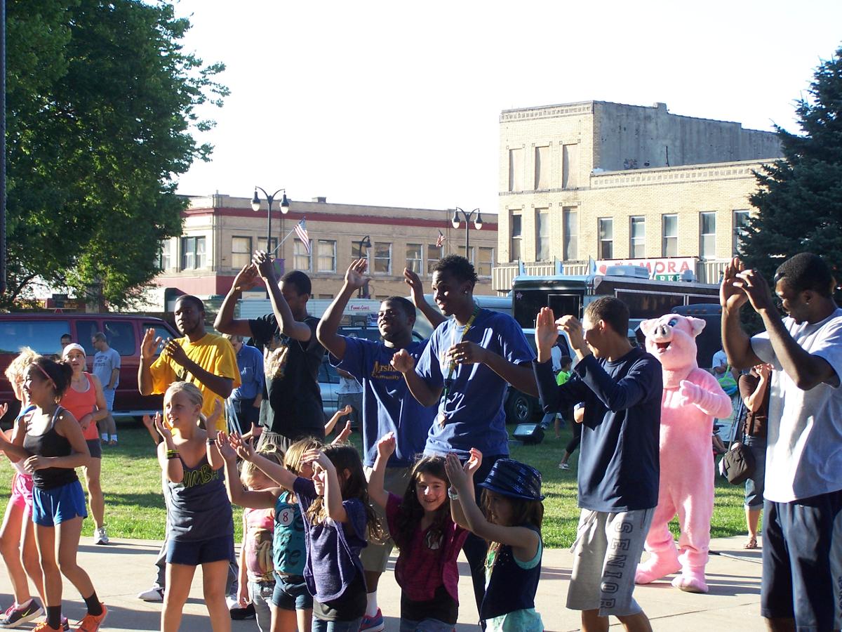 Members of the MCC men's basketball team take part in a Zumba session with local kids at the Marshalltown Oktemberfest