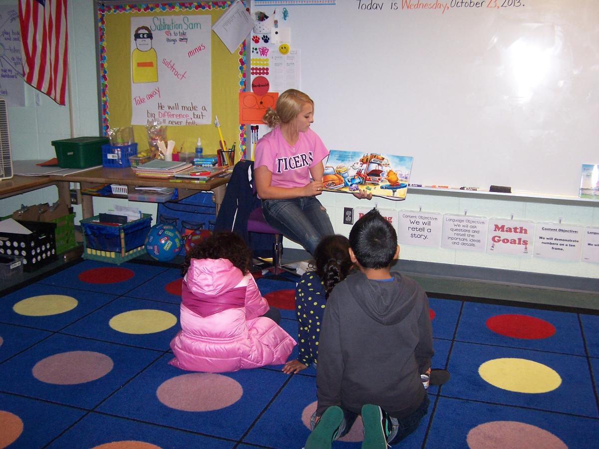Lexie Biehl, this week's ICCAC Offensive Player of the Week, reads to local children at Family Reading Night in October.